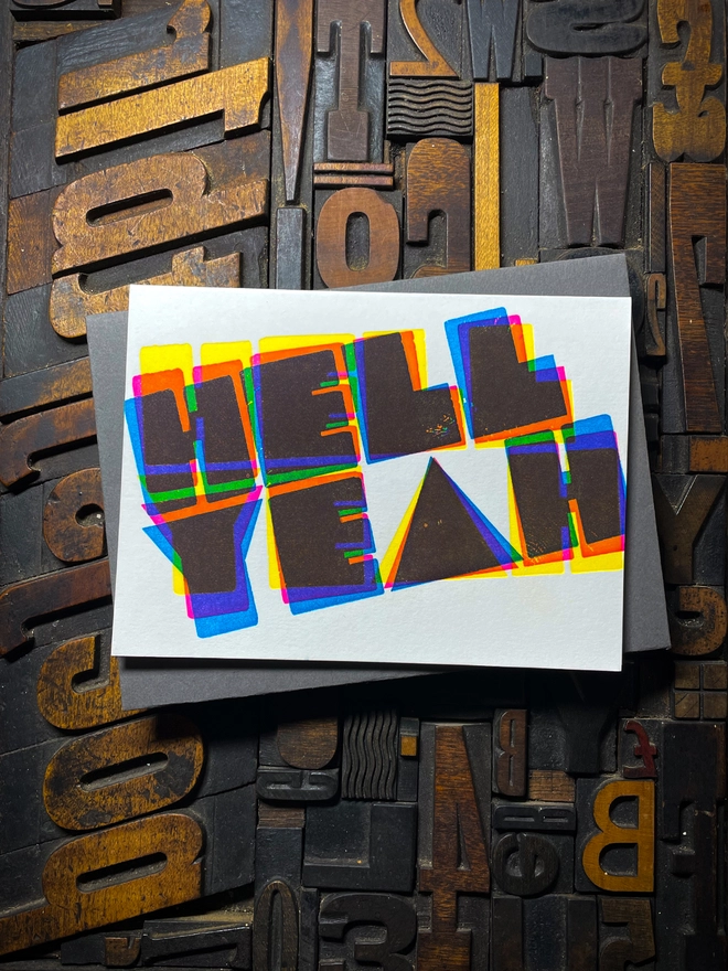 A congratulatory letterpress card using vibrant fluorescent inks the deep impression word HELL YEAH; in bold letters with a set of colourful envelopes. Perfect for exam results and graduations and other celebrations and milestones.