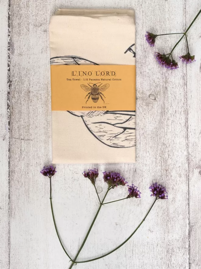 Picture of a tea towel with an image of a bee, taken from an original lino print