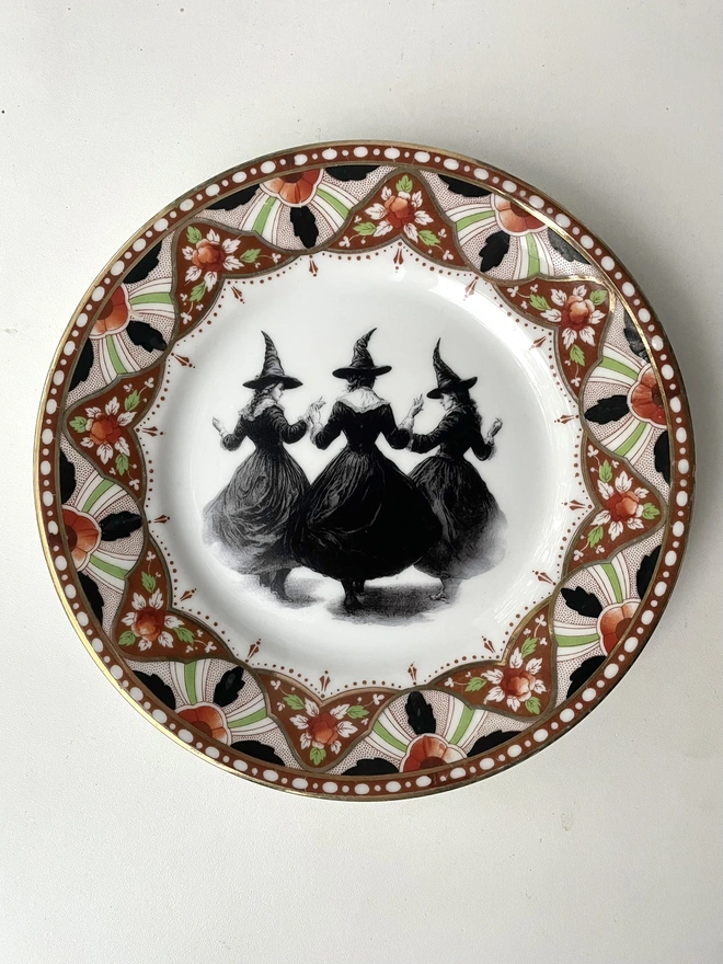 a vintage plate with an ornate floral border in the centre is a witch's coven