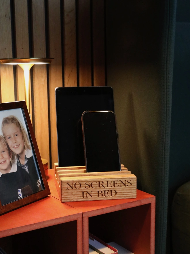 Phones on bedside table with photo of children