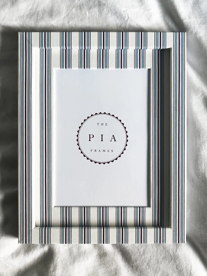 Sky & Scarlet Tailor Stripe Frame, a patterned colourful frame sitting on a plain white surface. 