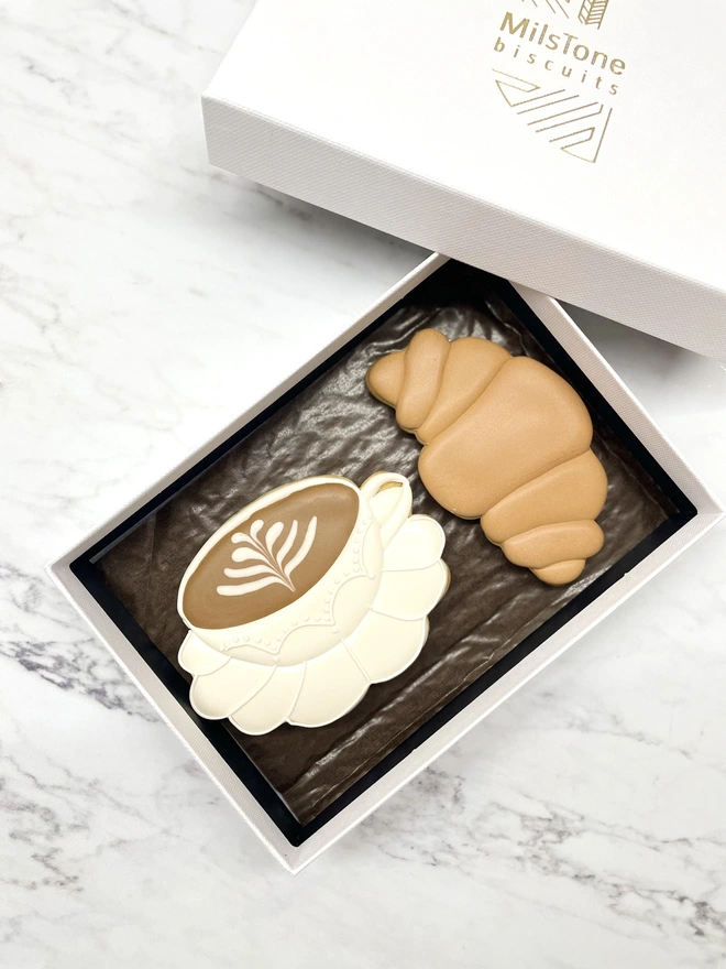 Hand-piped latte art coffee biscuit and croissant iced biscuit in elegant Milstone gift box.
