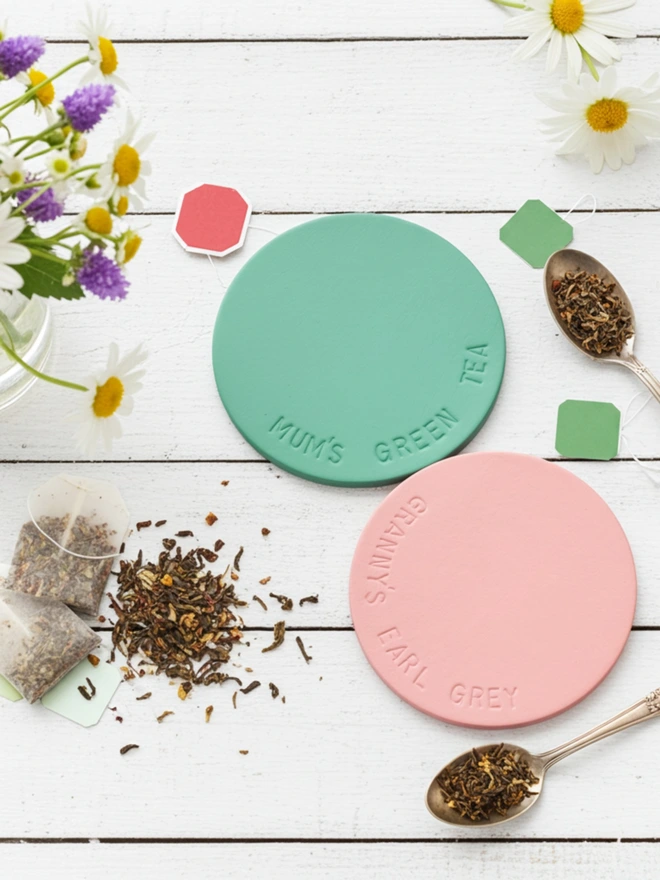 pink and mint coasters hand stamped with Grannys Earl Grey, with tea bags on a white wooden background.