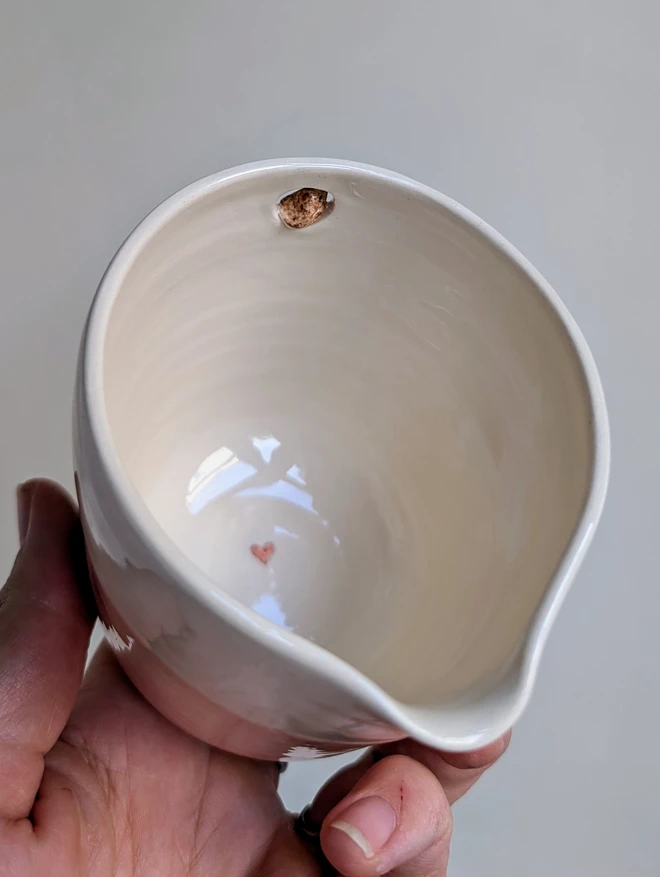 handmade ceramic white and pink jug with a tiny robin bird in a small cut out hole