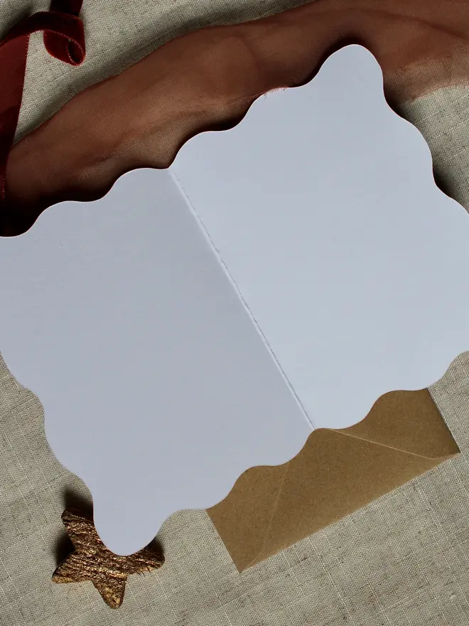 floral joy christmas card. wavy edged card decorated opened to show blank inside.