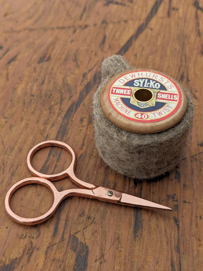 Sylko cotton reel scissors holder with scissors on table