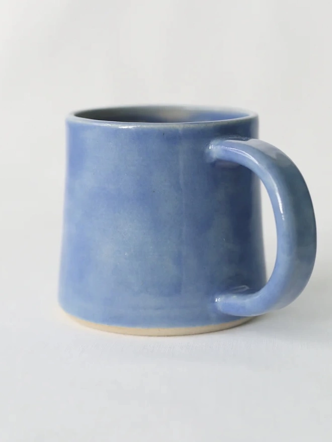 Ceramic Standard Mug, a colourful ceramic mug sitting on a plain surface against a grey backdrop. 