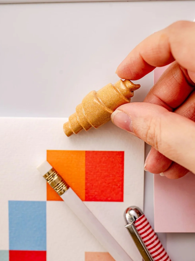 ceramic pastry magnets. a ceramic croissant magnet on a fridge door.