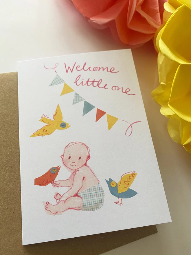 Yellow, pink and blue illustrated greetings card by Esther Kent, showing a little baby holding a bid, under bunting and handwriting that reads 'Welcome little one'.