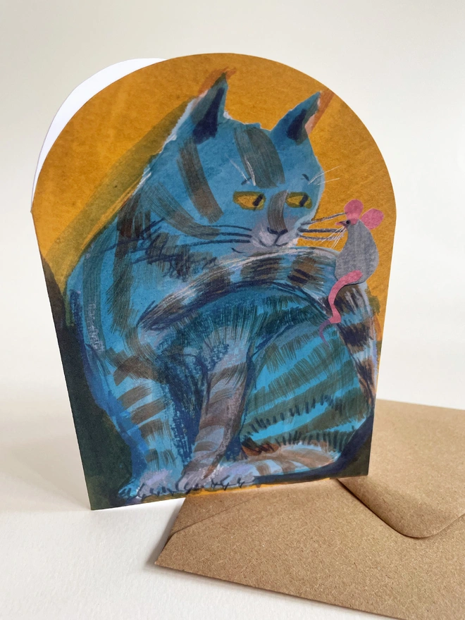 Esther Kent illustrated arch-shaped greeting card showing a blue striped cat looking at a mouse perched on its tail.