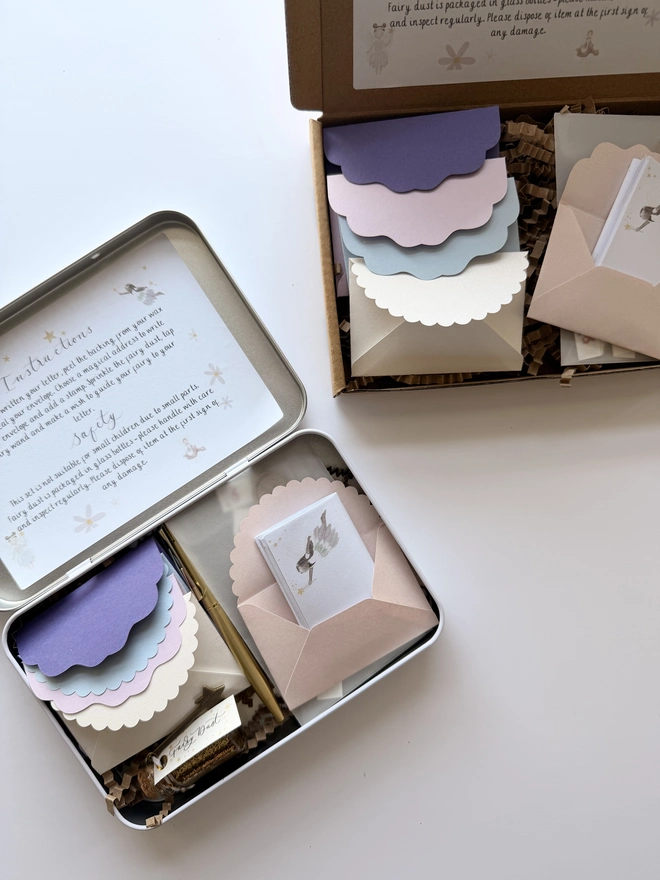 One tin and one box filled with whimsical writing sheets, envelopes, wax seals and miniature fairy stamps