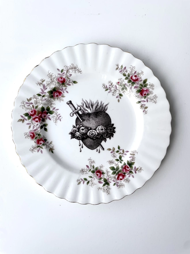 vintage plate with a red rose floral border, with a printed vintage illustration of a sacred heart in the middle 