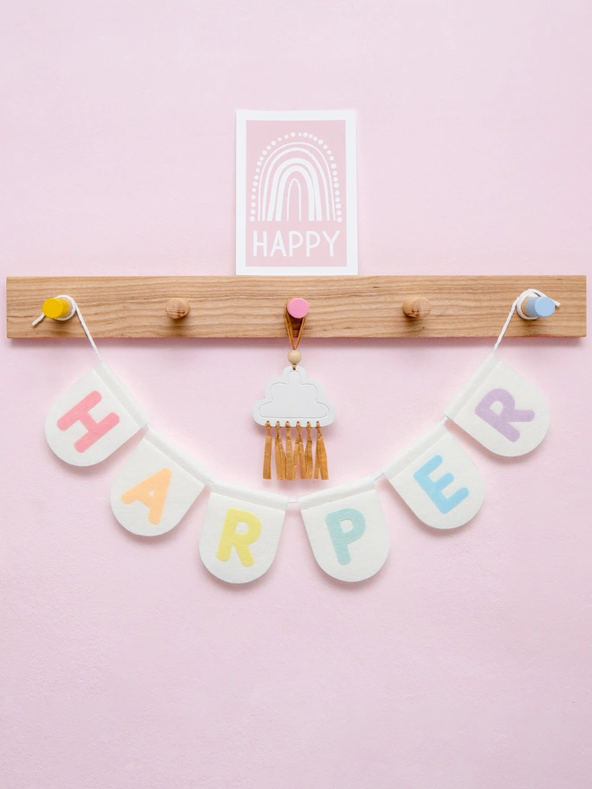 Personalised children's bunting. The text is a mix of soft pastels on white felt flags. 