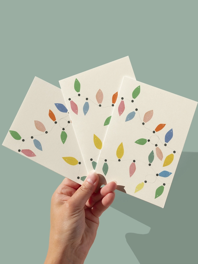 A minimal Christmas card featuring of pastel coloured fairy lights.