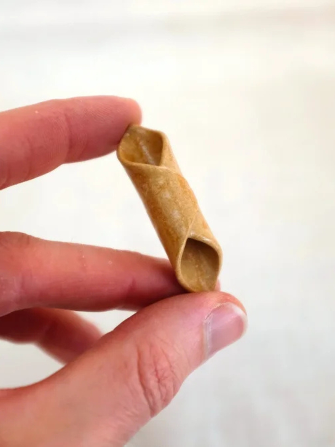 ceramic pasta magnet. a ceramic garganelli magnet photographed up close
