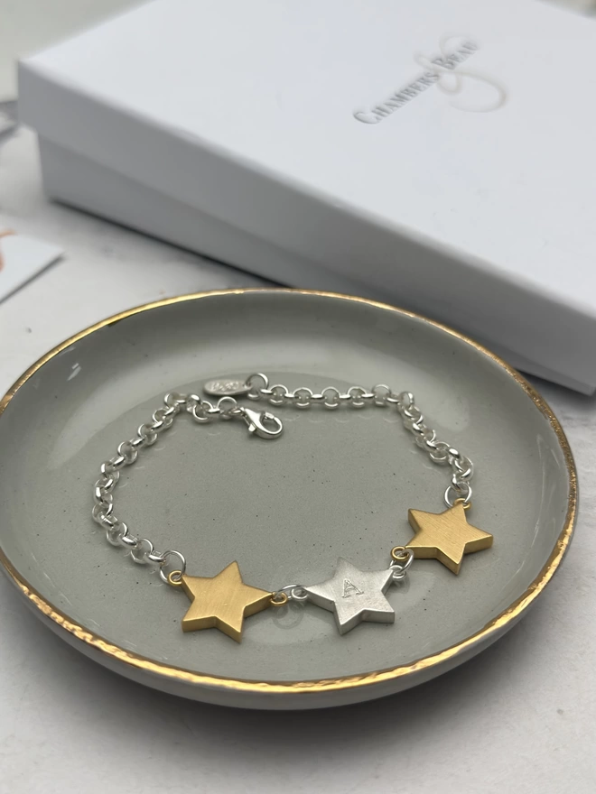 sterling silver belcher chain bracelet with two chunky gold star charms either side of one personalised sterling silver star charm