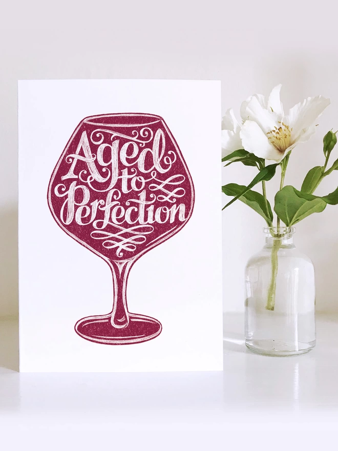 red wine birthday card with white flower in small vase