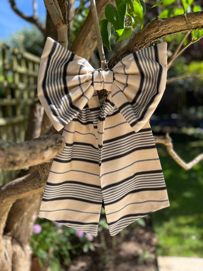 Large decorative bow made with Ian Mankin epire stripe charcoal fabric