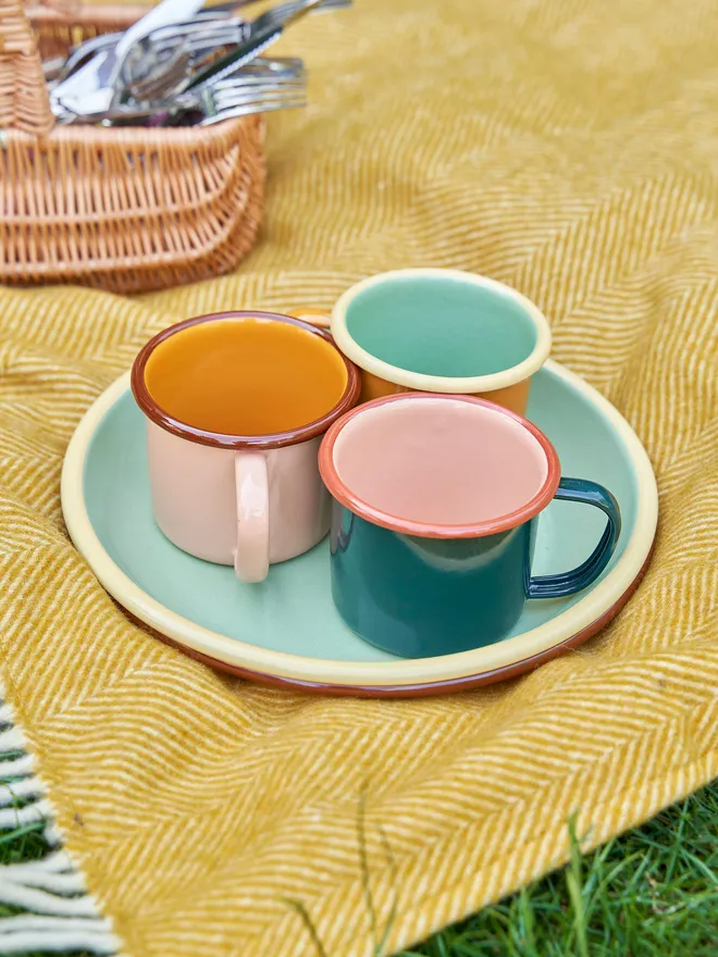 Emamel Mug Placed on a yellow picnic blanket 
