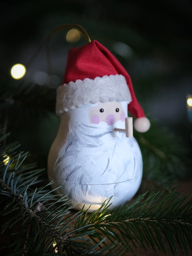 Handmade rustic Santa Christmas ornament with a white beard, rosy cheeks and red hat, with a tiny note to santa inside