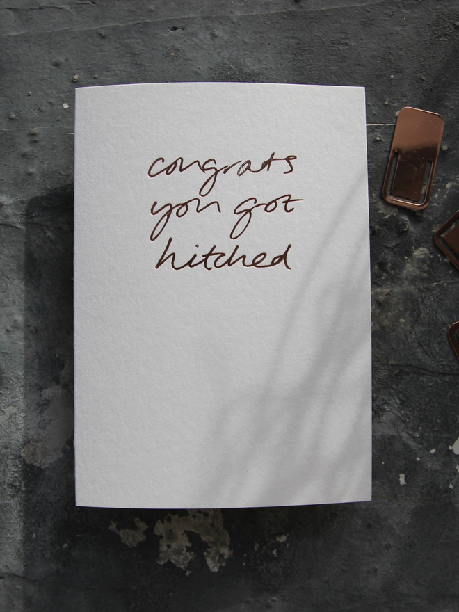 hand foiled card with a handwritten phrase that says Congrats You Got Hitched