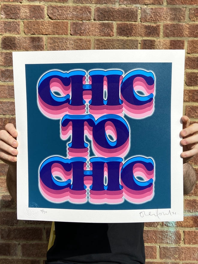 "Chic To Chic" Hand Pulled Screen Print in dark blue back ground square with the words chic to chic printed on top in retro lettering with different shades of pink and a white outline glow 