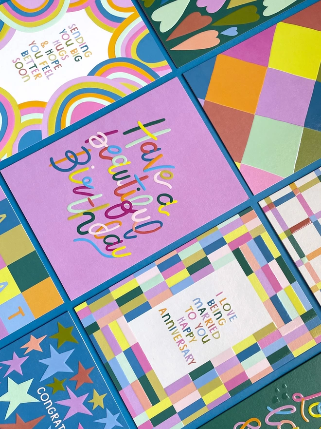 A flat lay of colourful cards from the Raspberry Blossom ‘Happiness’ greeting card collection
