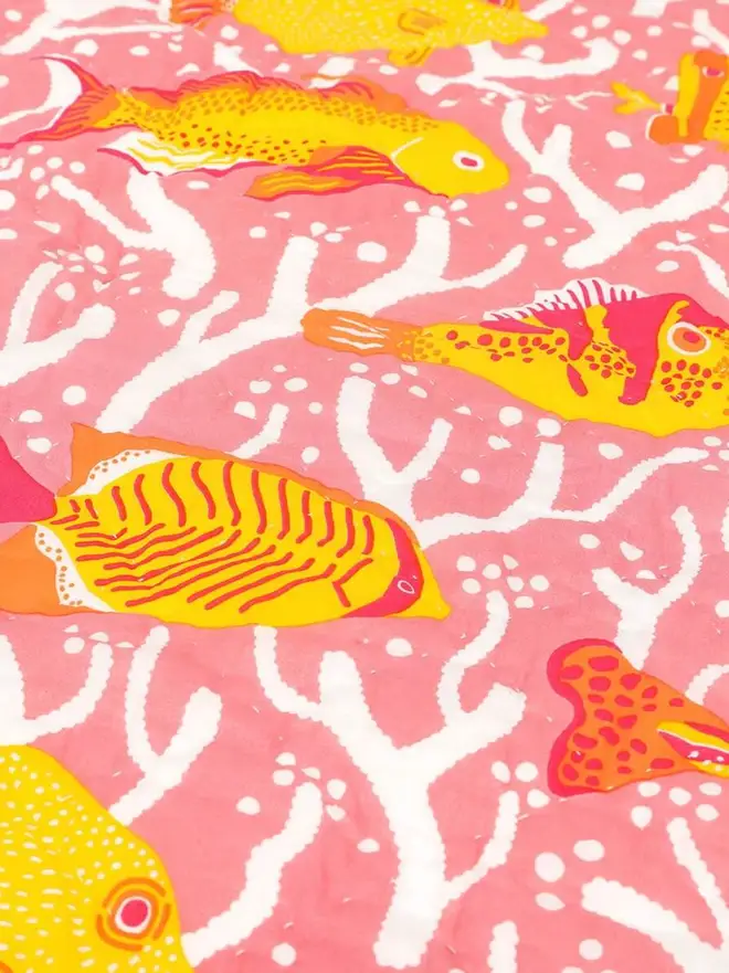 Pink Coral Reef Quilt, a pink quilt sitting on a white surface. 
