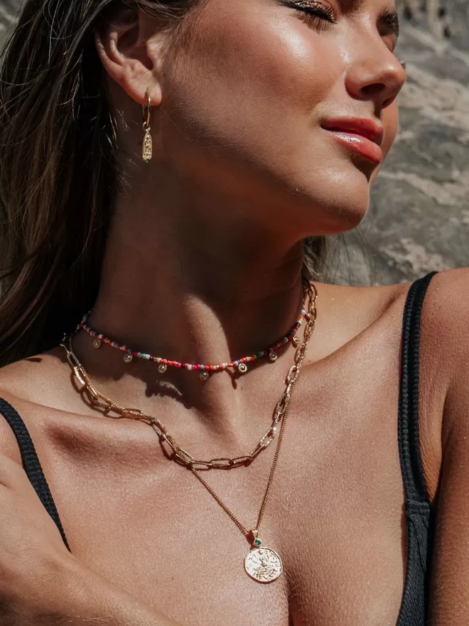 Model in sunshine wearing Loft & Daughter gold layering necklaces with colourful beads