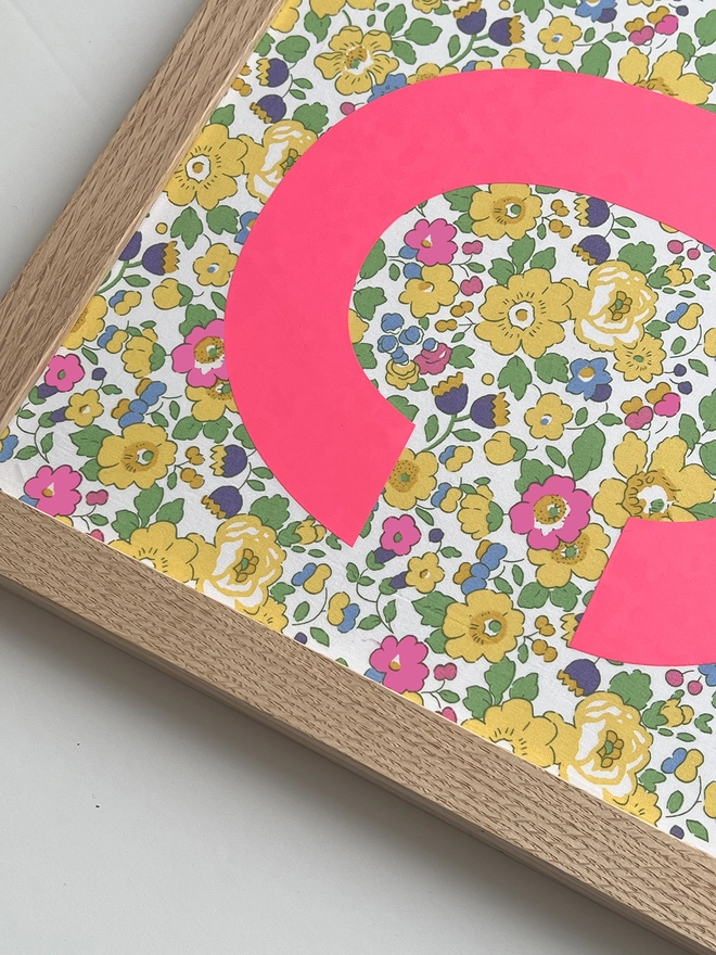 Personalised framed neon pink initial on Liberty Betsy yellow fabric - close up