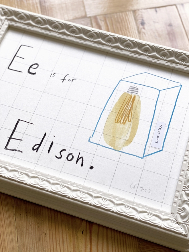framed drawing of Edison lightbulb and hand written E for Edison in white frame