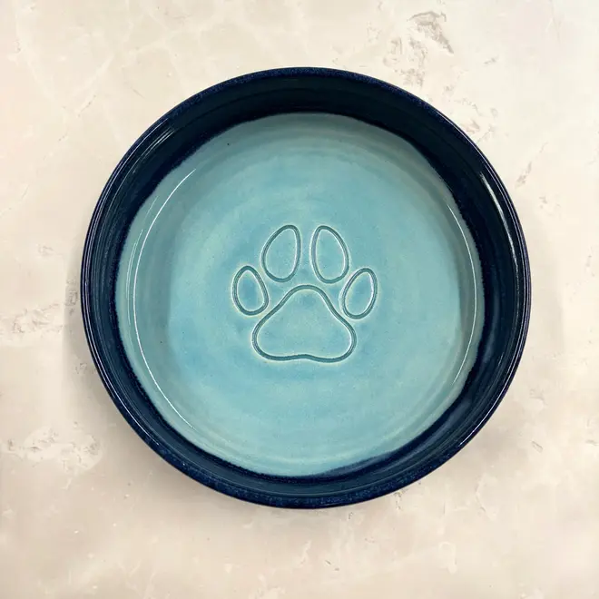 Landscape Dog Bowl, a colourful dog bowl sitting on a stone surface. 