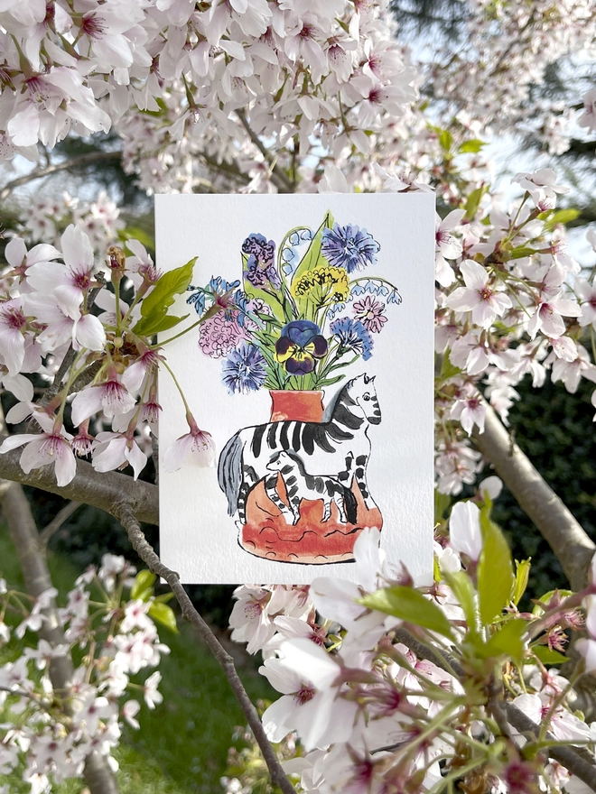 A greeting card featuring a zebra mother & child and flower bouquet