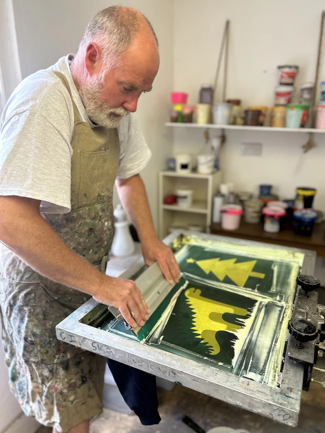 Man printing tshirts in studio