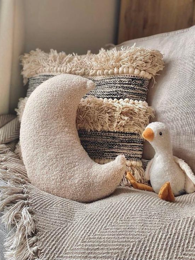 boucle moon pillow. a moon shaped pillow cushion in beige.
