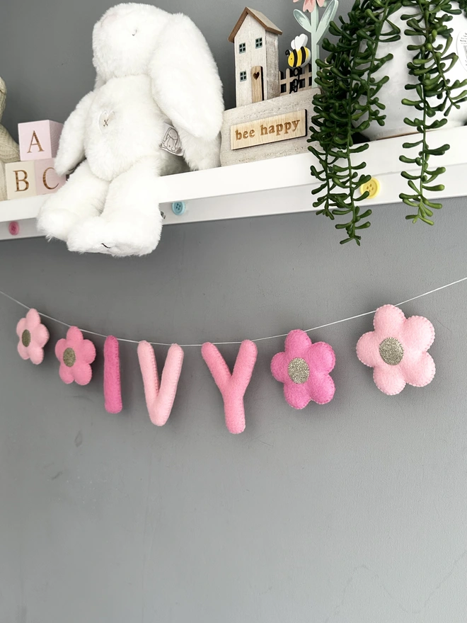 Personalised Name Icon Garland, a child’s name banner hanging  from a white shelf, nursery decoration, baby gift 