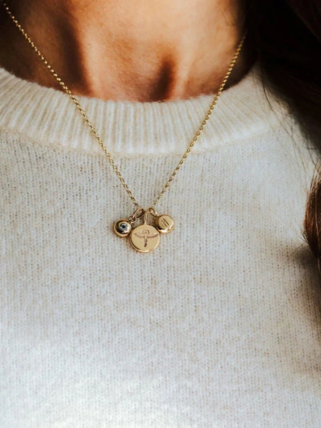 A woman wearing a 9ct Gold Phoenix Pebble Necklace against a white jumper