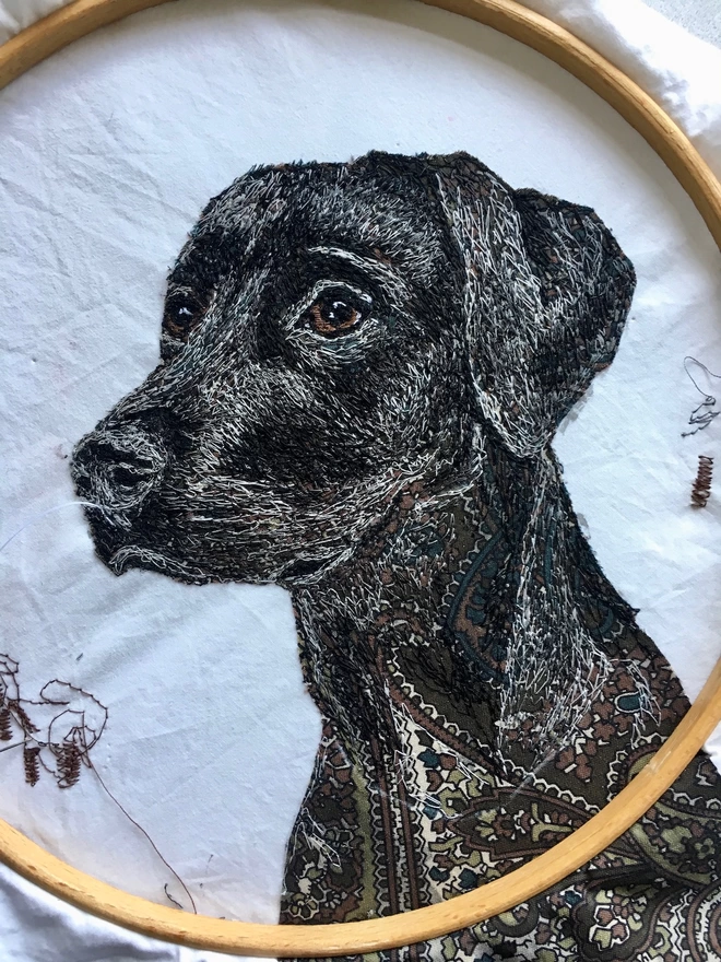closeup detail of embroidered portrait of a black labrador