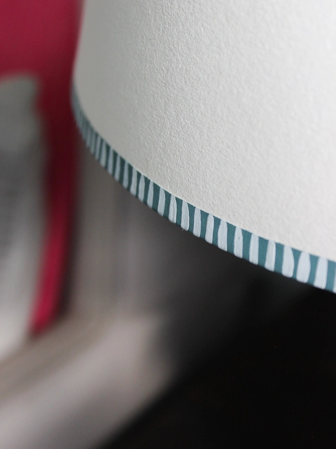 Close-up of bold stripe lampshade featuring hand-painted striped edge in blue. A pretty lampshade detail that shows the craftsmanship behind Studio Zef’s striped lampshades UK collection.