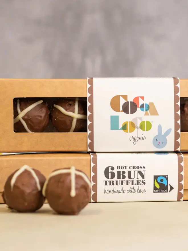 Close up image of chocolate easter truffles in a box next to some daffodills