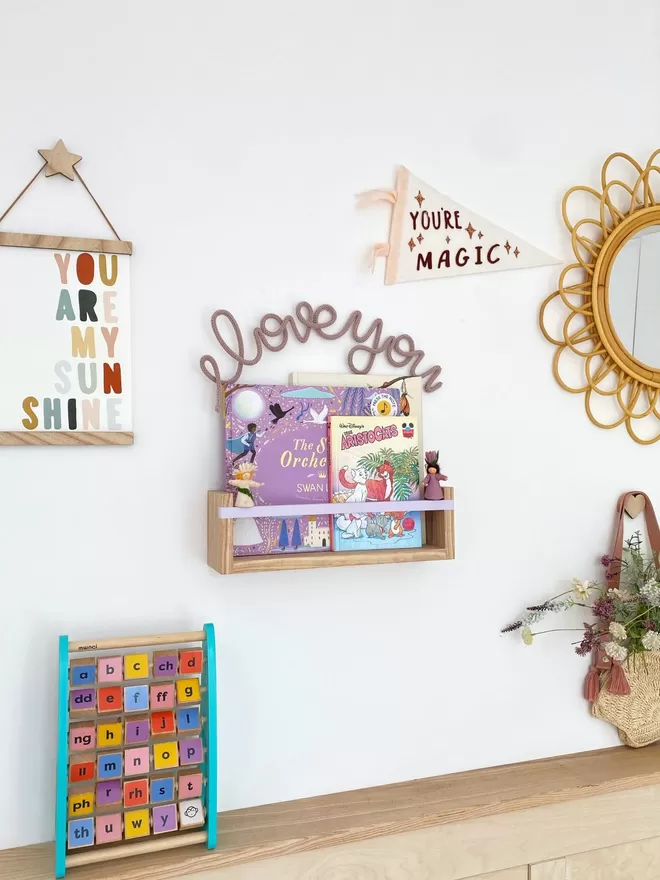 Pretty kids room decor, a solid wood bookshelf with a lavender painted bar 