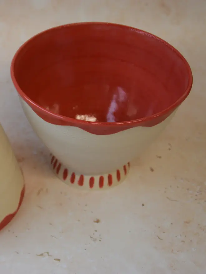 Handmade ceramic bowl — top angled view showing glossy red interior