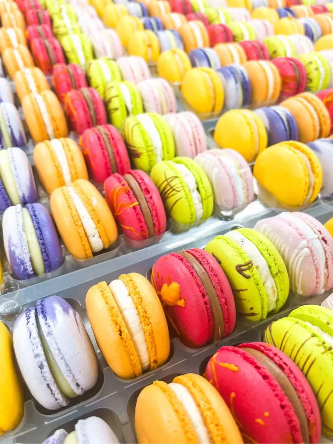 many colourful autumn macarons are arranged in a tray