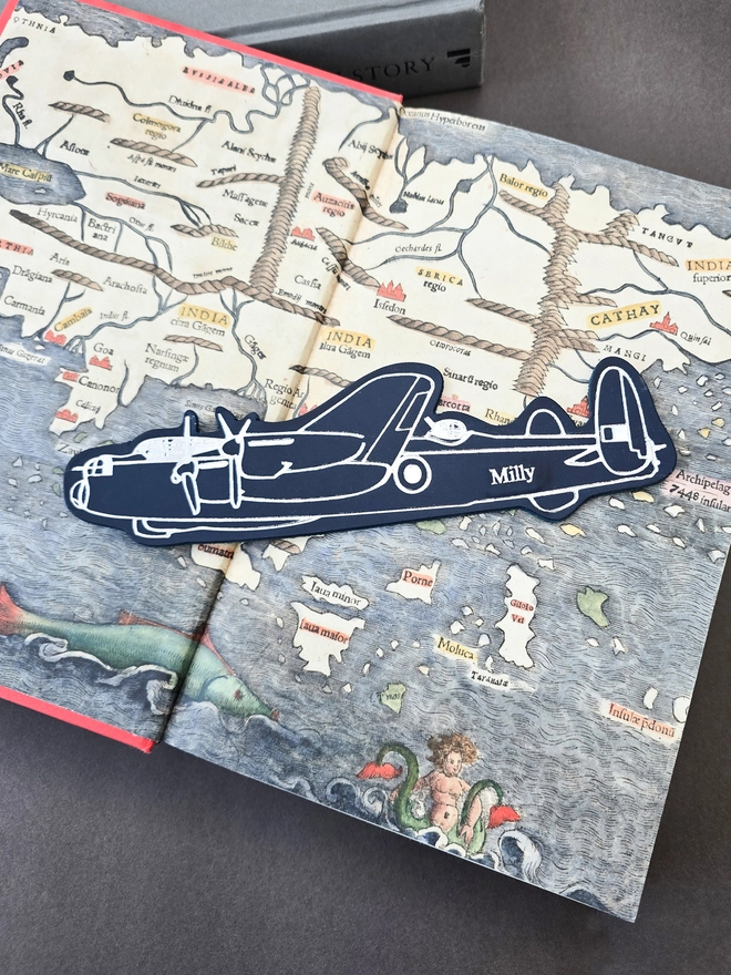 blue and silver leather lancaster bomber warplane bookmark on a book of maps