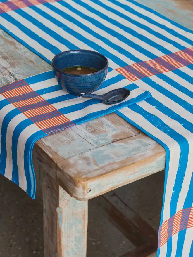 Blue and orange stripe table runner and napkin