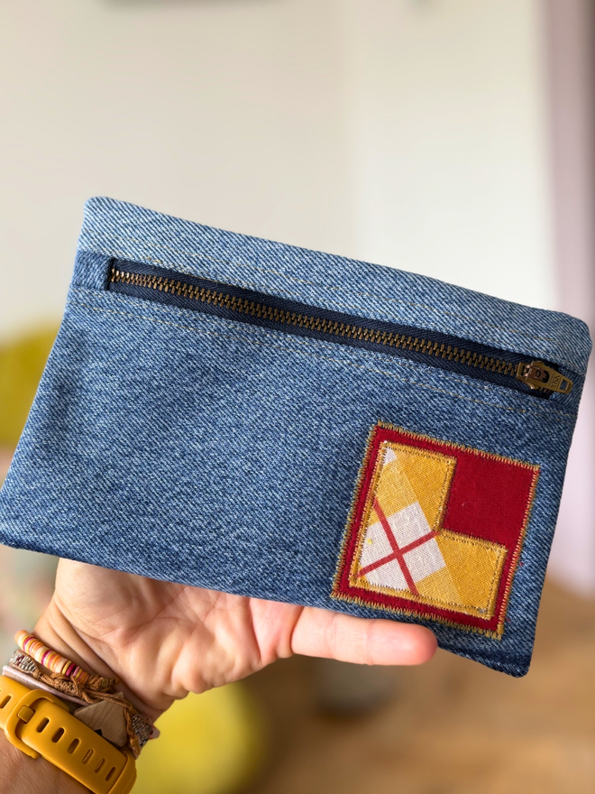Handmade pencil case made from reclaimed denim with a zip fastening and a bright vintage‑print initial on the front