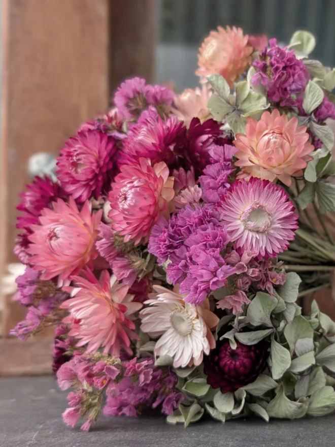 pink petals dried flower bouquet. bouquet of pink dried flowers tied up in a bunch.