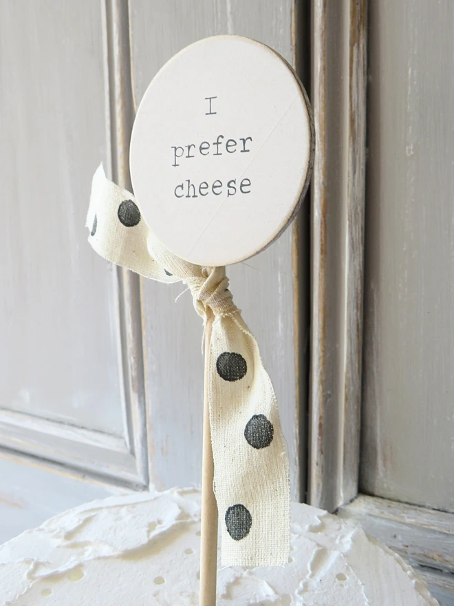 wooden circle shaped cake topper with hand painted message and custom ribbon
