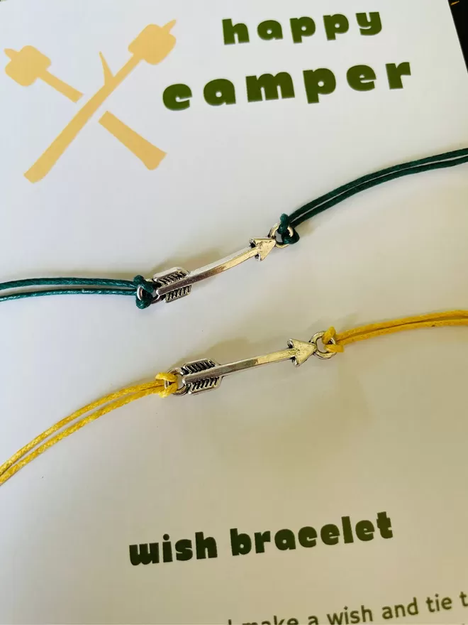 Close up of happy camper wish bracelet, with a silver arrow charm.