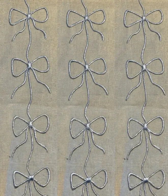 Hand Painted Bow Print Sustainable Linen Table Runner, a table runner with a metallic silver bow design. 